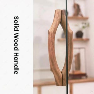 Könnte beinhalten: Ein Griff aus massivem Holz mit einem natürlichen, organischen Design. Der Griff besteht aus hellbraunem Holz und ist an einer Glasscheibe befestigt. Der Text "Solid Wood Handle" ist vertikal auf der linken Seite aufgedruckt.