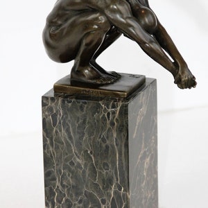impressive bronze statue of a diver on a veined marble base