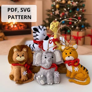 May include: Felt animal ornaments, including a lion, zebra, giraffe, elephant, and tiger, each with a red scarf and snowflake detail. The ornaments are displayed in front of a Christmas tree. Text on the image reads "PDF, SVG PATTERN."