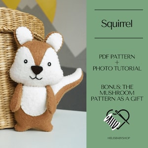 May include: A brown and white felt squirrel toy with a smiling face. The toy is sitting on a white surface next to a wicker basket. The image includes the text "Squirrel", "PDF Pattern + Photo Tutorial", "Bonus: The Mushroom Pattern as a Gift", and "Helisbabyshop".