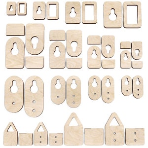 Puede incluir: Surtido de ganchos de pared de madera en varias formas y tamaños. Los ganchos están hechos de madera natural y tienen un aspecto rústico. Algunos ganchos tienen un solo agujero, mientras que otros tienen dos o tres agujeros.