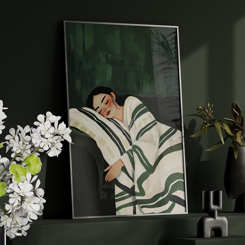 Pode incluir: Uma mulher com cabelo escuro dorme em um cobertor listrado branco e verde. O cobertor est&aacute; enfiado ao redor dela e ela est&aacute; deitada de lado com a cabe&ccedil;a apoiada em um travesseiro branco. O fundo &eacute; verde escuro.