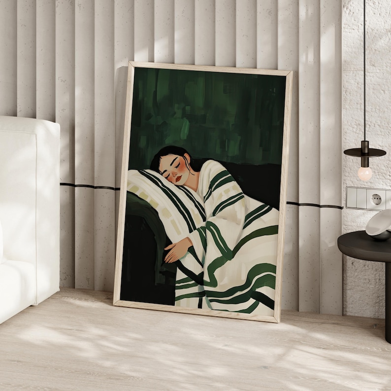 Pode incluir: Uma ilustra&ccedil;&atilde;o emoldurada de uma pessoa dormindo em um sof&aacute;. A pessoa est&aacute; enrolada em um cobertor branco e verde. O fundo &eacute; de cor verde escura.
