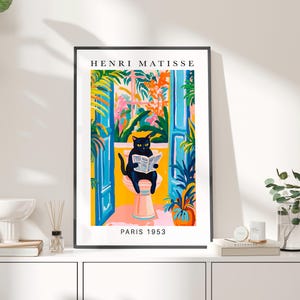 Op de afbeelding: Een kleurrijke illustratie van een zwarte kat die op een toilet zit en een krant leest. De achtergrond toont een raam met uitzicht op een weelderige tuin. De tekst "HENRI MATISSE PARIS 1953" is onder de afbeelding gedrukt.