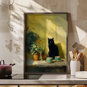 May include: A framed art print depicts a black cat sitting near potted plants and two teacups. The artwork has a warm color palette with yellow and green tones. The cat has bright yellow eyes.