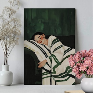 Puede incluir: Una mujer duerme plácidamente en una cama con una manta a rayas verdes y blancas. La manta está metida a su alrededor y ella está descansando la cabeza sobre una almohada blanca. El fondo es de color verde oscuro.