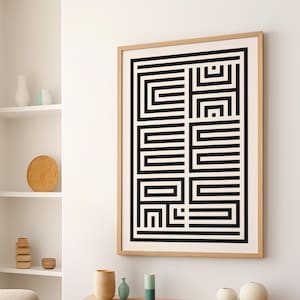 Puede incluir: Lámina de arte geométrico en blanco y negro en un marco de madera clara. La obra de arte presenta un patrón repetitivo de gruesas líneas negras que forman un diseño laberíntico sobre un fondo crema. La impresión enmarcada se muestra en una pared blanca.