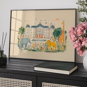 Op de afbeelding: Ingelijste kunstdruk met een grillige illustratie van een groot gebouw met een rode luifel, een olifant, een leeuw en een giraffe. Het kunstwerk is geplaatst tegen een beige achtergrond en zwart omlijst.