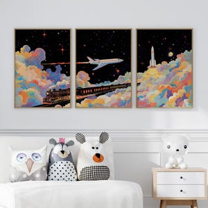 May include: Three framed art prints showing a train, aeroplane, and rocket against a starry night sky. The artwork features colourful clouds in shades of orange, yellow, and blue. The prints are displayed above decorative pillows and a bedside table.