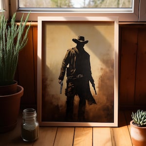 May include: A framed painting of a cowboy silhouette in a dusty brown landscape. The cowboy is wearing a wide-brimmed hat and a long coat. He is holding two pistols.