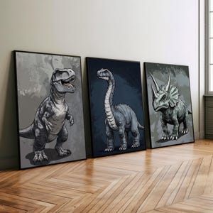 Può includere: Tre illustrazioni incorniciate di dinosauri. La prima mostra un Tyrannosaurus Rex grigio, la seconda mostra un Brachiosaurus grigio e la terza mostra un Triceratops grigio.