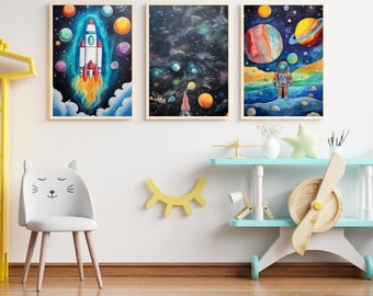 May include: Three framed watercolor paintings depicting space scenes. The first painting shows a rocket ship launching into a blue and purple galaxy. The second painting shows a dark blue galaxy with stars and planets. The third painting shows an astronaut standing on a planet with a rainbow sky.