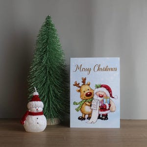 Weihnachtskarte auf englisch. Weihnachtskarte in Englisch. Weihnachtsmann und ein Reh.