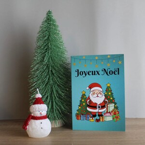 Weihnachtskarte auf französisch. Weihnachtsmann mit Geschenken und Tannenbäumen. Karte von Noël in Französisch. Père Noël mit Cadaux und Bäume von Noël.