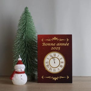 Neujahrskarte auf französisch. Neujahr Uhr. Karte von Nouvel in Französisch. Horloge du Nouvel An.
