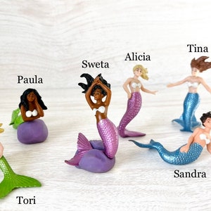 Puede incluir: Un conjunto de diez figuras de sirenas, cada una con una cola y un cabello de color diferente. Las sirenas se llaman: Tori, Paula, Sweta, Alicia, Tina, Sandra.