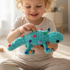 May include: A turquoise crocheted dinosaur toy with colorful, round accents. The plush toy has a long tail, four legs, and a smiling face. The toy is designed for children.