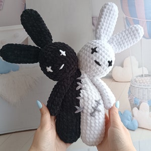 Pode incluir: Um brinquedo de coelho de pel&uacute;cia feito &agrave; m&atilde;o, dividido verticalmente em preto e branco. O coelho tem orelhas longas, tra&ccedil;os faciais costurados e uma costura costurada no meio. O brinquedo &eacute; segurado por uma pessoa com esmalte azul claro.