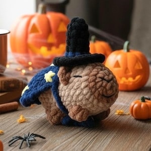 May include: A crocheted capybara plush toy wearing a black pointed wizard hat and a dark blue cape decorated with yellow stars. The plush has a light brown textured body with closed eyes and a small smile, crafted from soft yarn material.