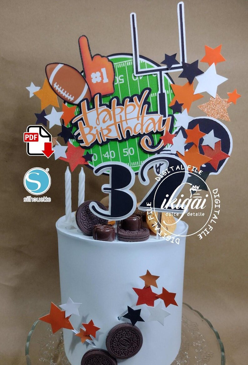 K&ouml;nnte beinhalten: Ein wei&szlig;er Geburtstagskuchen, verziert mit Football-Themen-Toppern. Die Topper umfassen einen Football, einen Schaumstofffinger, ein Tor und sternf&ouml;rmige Dekorationen. Der Kuchen ist mit den Worten "Happy Birthday" und der Zahl "32" verziert.