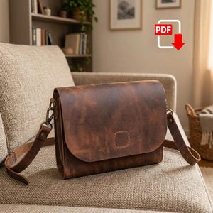 May include: A dark brown leather messenger bag with a rectangular flap, a stitched square detail on the front, and an adjustable shoulder strap attached with metal hardware. The bag features a distressed finish and a structured rectangular shape.