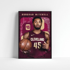 May include: Donovan Mitchell, a basketball player for the Cleveland Cavaliers, wearing a maroon jersey with the team's logo and the number 45. He is holding a basketball and has a determined expression on his face.