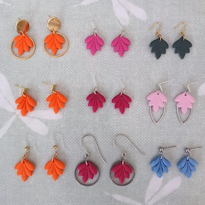 Puede incluir: Surtido de pendientes de arcilla polimérica hechos a mano en varios colores y estilos. Los pendientes presentan un diseño de hoja y están disponibles con cierres de estilo dorado, plateado o de gancho.