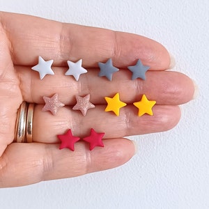 5 pairs of handheld star shaped stud earrings in grey, yellow, red and rose gold