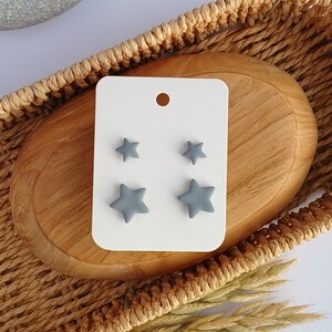 2 pairs of grey star shaped stud earrings in on a white display card