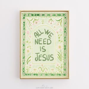 May include: A framed watercolor print with the text "ALL WE NEED IS JESUS" in green lettering. The artwork features a light green background with floral and leaf accents in pink and green, framed in a gold tone.