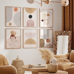 May include: Six abstract art prints in gold frames with geometric shapes and line drawings in shades of brown, beige, and black. The prints are hung on a white wall above a wicker basket and a brown couch.
