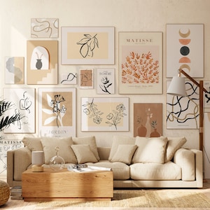 May include: A living room interior design with a beige sofa and a coffee table. The walls are decorated with a collection of abstract art prints in black, white, and brown. The prints feature various designs, including leaves, flowers, and geometric shapes. The text on the prints includes "Jardin", "Boheme", and "Matisse".
