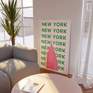 May include: A pink and green poster with the text "NEW YORK" repeated multiple times. The poster features a pink silhouette of the Empire State Building.