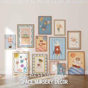 May include: A set of framed art prints with space-themed illustrations. The prints depict rockets, planets, and animals in astronaut suits, using blues, oranges, and yellows. Text on the prints reads "Bundle of +50 prints" and "SPACE NURSERY DECOR". The frames are a warm brown.