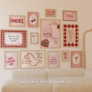 May include: A collection of framed art prints with romantic themes. The prints feature phrases like "AMORE" and "DARLING", along with illustrations of hearts, doves, and candles. The color palette includes red, pink, and cream.