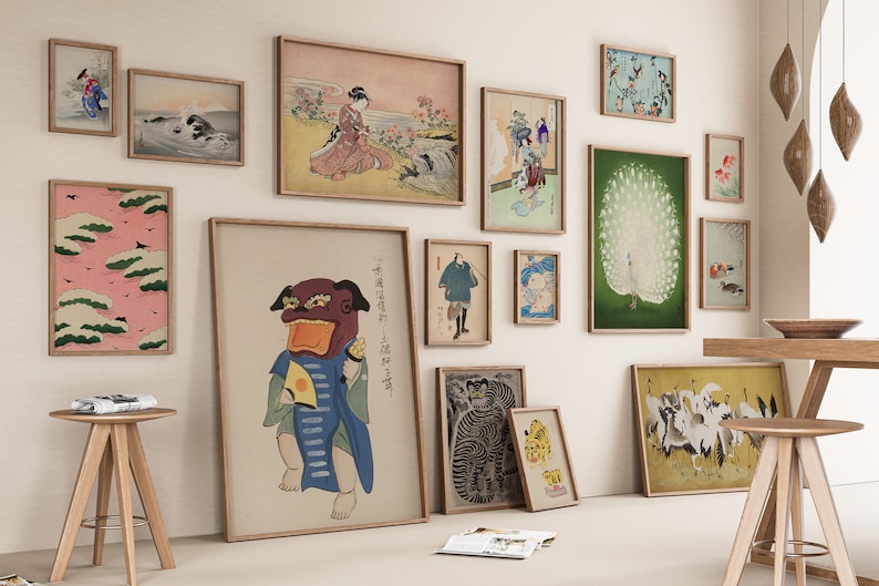 May include: A gallery wall with a variety of framed prints, including Japanese art, a peacock, and a tiger. The prints are arranged in a symmetrical pattern on a white wall.