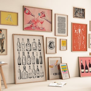 May include: A gallery wall with various framed prints featuring a cocktail theme. The prints include illustrations of bottles of liquor, cocktails, and bar-related imagery. The prints are in a variety of colors and styles, including black and white, red, and yellow.