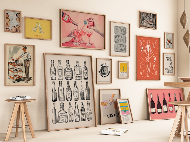 May include: A gallery wall with various framed prints featuring a cocktail theme. The prints include illustrations of bottles of liquor, cocktails, and bar-related imagery. The prints are in a variety of colors and styles, including black and white, red, and yellow.
