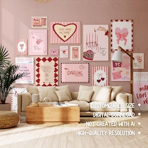 May include: A collection of framed art pieces in shades of pink and red, arranged on a pink wall above a beige sofa. The artwork includes hearts, cherubs, and text like "Darling" and "More Amore Per Favore." A wooden coffee table and a floor lamp are in the foreground.