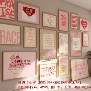 May include: A collection of framed Christian wall art with inspirational quotes and phrases in pink and white. The art includes the words "Praise," "Grace," "Love Like Jesus," and "Jesus is the Sweetest Thing." The frames are displayed on a light-colored wall.