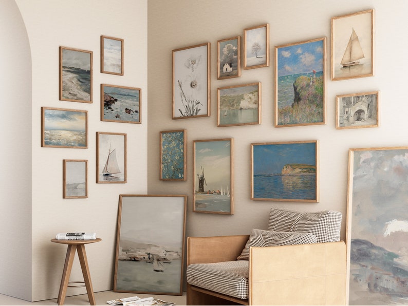 Puede incluir: Una pared de galer&iacute;a con una variedad de obras de arte enmarcadas, incluyendo paisajes marinos, paisajes y dise&ntilde;os abstractos. La pared est&aacute; pintada de un color beige claro y los marcos son todos de un color madera claro.