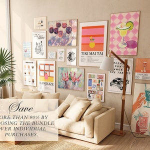 May include: A collection of 12 colorful cocktail-themed prints, including a pink and orange Tiki Mai Tai print, a green margarita print, and a print with a group of hands holding cocktails. The prints are arranged on a wall in a living room setting with a beige sofa and a wooden floor.