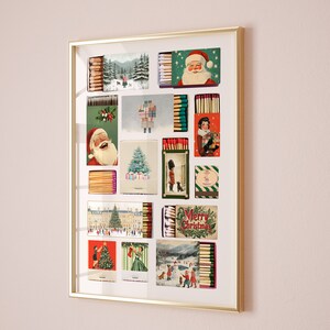 May include: A framed collage of vintage matchboxes with Christmas-themed illustrations. The collage features images of Santa Claus, a Christmas tree, and other holiday scenes. The matchboxes are arranged in a grid pattern and are surrounded by a gold frame.