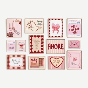 May include: A collection of framed art prints with a Valentine's Day theme. The prints feature hearts, cupids, and romantic phrases in pink, red, and cream colors. Some prints have a vintage aesthetic, with handwritten text and decorative borders.