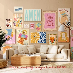 May include: A collection of colorful art prints displayed on a wall above a beige sofa. The prints feature various designs, including text, illustrations of angels, flowers, and animals. The word "AMEN" is prominently displayed in a large, light blue font.