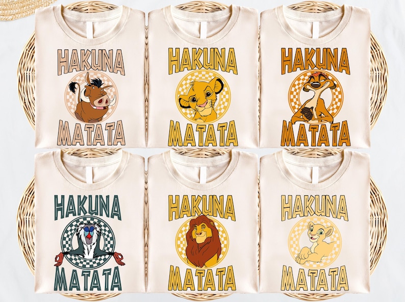six white t-shirts with the text "HAKUNA MATATA" printed on them, featuring illustrations of the main characters from the Disney film "The Lion King".