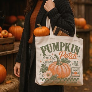 Peut inclure: Un sac fourre-tout en toile couleur crème avec une impression graphique d'une grosse citrouille orange et de feuilles vertes. Le texte indique PUMPKIN Patch, FRESH FROM THE PATCH, FARM FRESH, LOCALLY GROWN, PUMPKINS CORN MAZE APPLE CIDER.