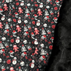 May include: Black fabric with a repeating pattern of red and white holiday-themed illustrations. The design includes skeleton gingerbread men, snowmen, Christmas trees, candy canes, snow globes, bats, and skulls wearing Santa hats.