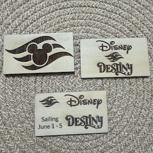 May include: Three rectangular wooden plaques with laser-etched designs. One features the Mickey Mouse silhouette within a stylized wave, while the others display "Disney Destiny" with a ship icon. One plaque also includes "Sailing June 1-5".