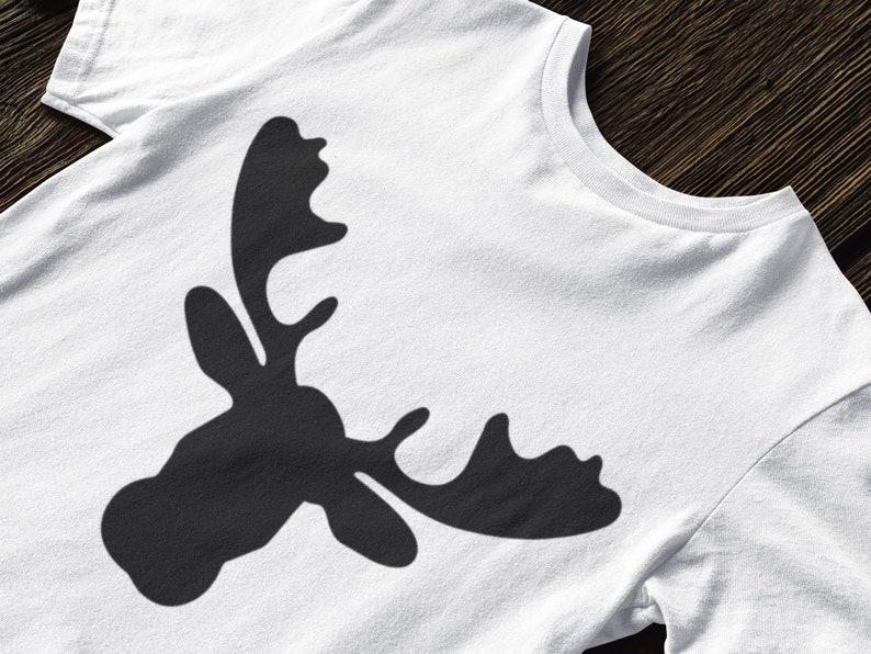 May include: A white t-shirt with a black silhouette of a moose head with antlers.